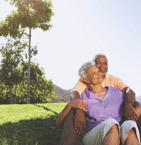 happy older couple sitting in park