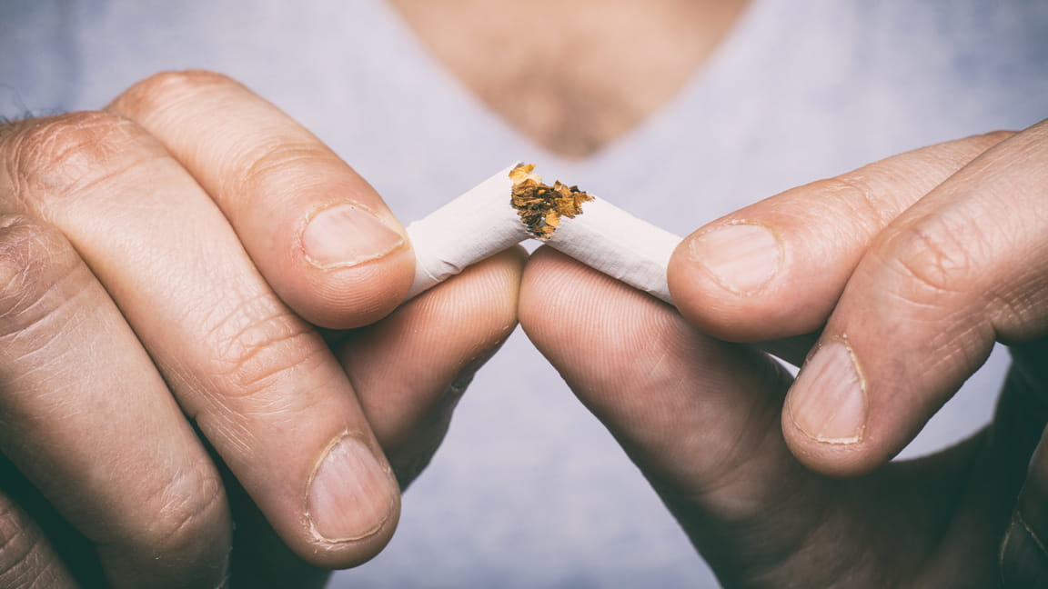 close up of man's hands breaking cigarette